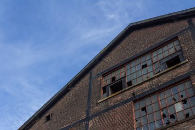 Terk edilmiş endüstriyel tuğla bina pencereleri kırık, yatay görünümlü.