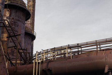 Endüstriyel bir alanın süpürme tüpleri ve kolonları, ağır paslanmış metal, yatay görünüm