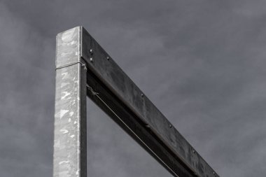 Koyu gri gökyüzüne karşı devasa açılı galvanize çelik kirişler, kopyalama alanı, yatay görünüm