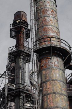 Merdivenleri ve kaldırımları olan bacalar, endüstriyel çelik üretim alanı, dikey görünüm