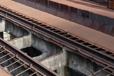 Paslı metal geçitli, yatay görünümlü yüksek tren rayları.