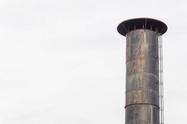Gri gökyüzü, kopyalama alanı, yatay görünümü ile izole edilmiş dış bağlı kafes merdiveni ile bir bacanın tepesinde