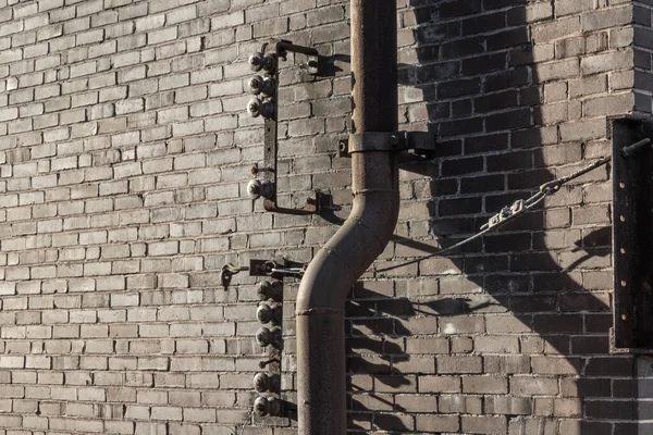 Lange Schatten Von Knöpfen Rohren Und Metallbügeln Gegen Eine Ziegelwand — Stockfoto