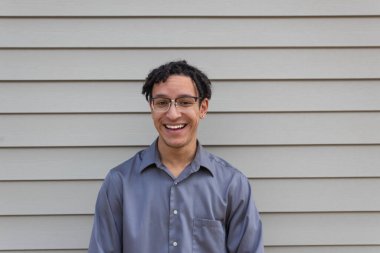 Gülen genç milenyum adamı, yakışıklı melez erkek doğal saç kıvrımlı, yatay görünüşlü.