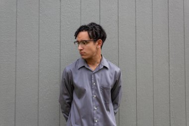 Yakalı genç bir adam, ciddi davranışlar, profil görüşü, gözlüklü siyah saçlı, korkunç, yatay görünümlü.