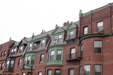 Eski kahverengi apartman binalarının önünde çeşitli mimari stiller ve bitirmeler, yatay görünüm gösteriliyor.