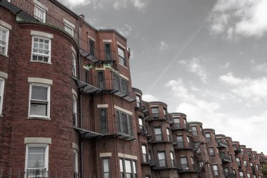 Gri gökyüzüne karşı eski tuğla apartmanların yuvarlak yüzleri, yatay görünüm