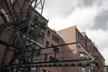 Eski bir apartmanın arka tarafındaki yangın çıkışında yatay bir görünüm var.