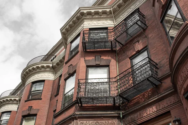 Elaborate wrought iron railings and frieze details on the face of old brownstones, horizontal aspect
