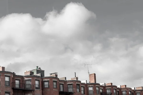 View along top edge of old brownstone apartments, gray sky copy space, horizontal aspect