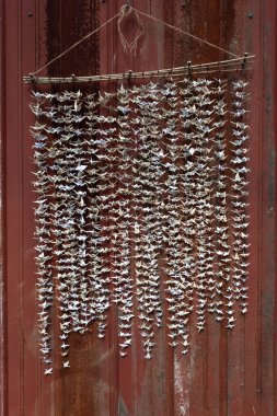 1000 origami katlanmış kağıt vinç heykeli eski kırmızı teneke kaplama arka planına karşı dikey görünüm