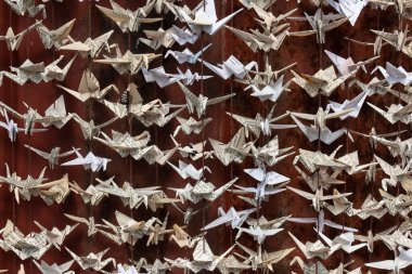 1000 origami katlanmış kağıt turna heykelinin çok yakından görüntüsü eski kırmızı teneke kaplamalı yatay görünümün arka planına karşıdır