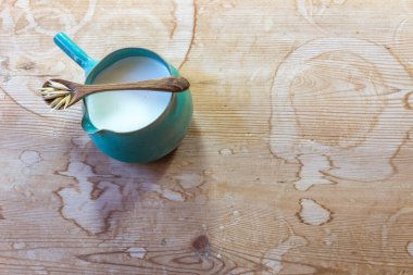 Küçük seramik sürahi yulaf sütü ile ahşap kaşık ve yulaf, fotokopi alanı, yatay görünüm