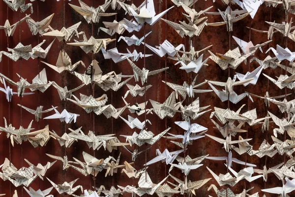 1000 origami katlanmış kağıt turna heykelinin çok yakından görüntüsü eski kırmızı teneke kaplamalı yatay görünümün arka planına karşıdır