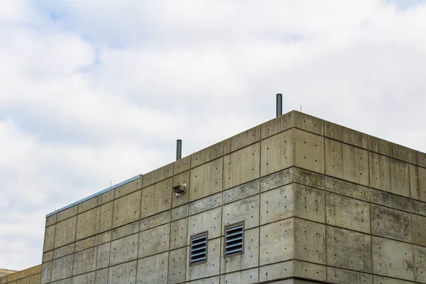 Exterior of a formed concrete slab building with side vents, horizontal aspect