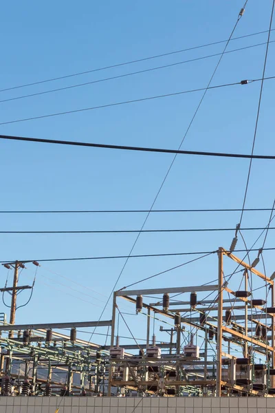 View over a wall of a power sub station on a cloudless day, copy space, vertical aspect