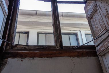 Papaz evinin penceresinden yukarı bak, ağır su hasarı açık, yatay görünüm