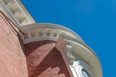 Tuğla bir binanın dış cephesinde beyaz boyalı korseler ve parlak mavi bir gökyüzü. Boşluğu kopyala, yatay görünüm