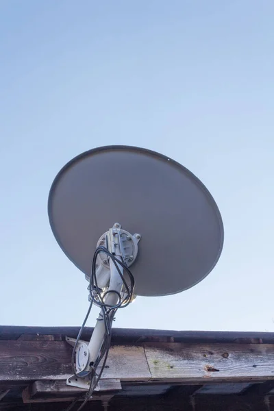 古い木材ファシア コピースペース 垂直面に取り付けられた衛星皿の背面図 — ストック写真