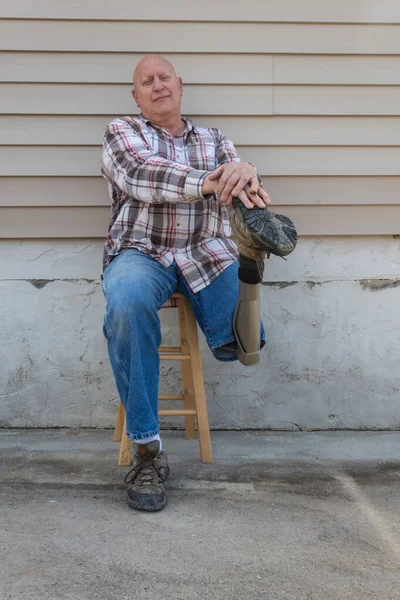人工脚の靴の上で手を休める座席の切断男 コピースペース 垂直面 — ストック写真
