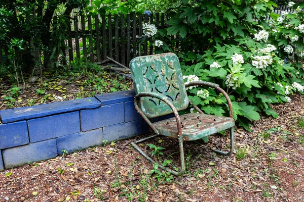 青いブロック壁に対して空の緑の金属椅子 老化死悲しみ不在の概念 水平方向の側面 — ストック写真