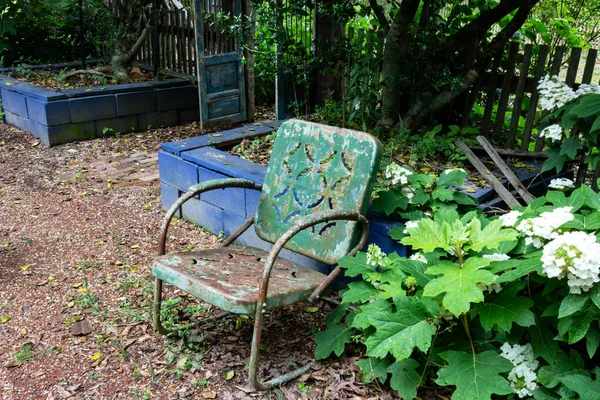 空荡荡的旧绿色金属椅子靠着蓝色的墙 老化的死亡哀伤的概念 横向方面 — 图库照片