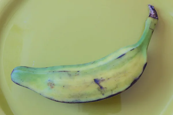 緑のプレート上の半分熟したブルロバナナの近いビュー オリノコ ブルージュ ホッグまたはラルゴバナナ 白に分離 水平方向の側面 — ストック写真