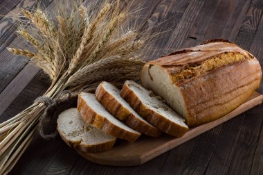 Bir kesme tahtası ve kulakları ahşap üzerine buğday ekmek dilimleri