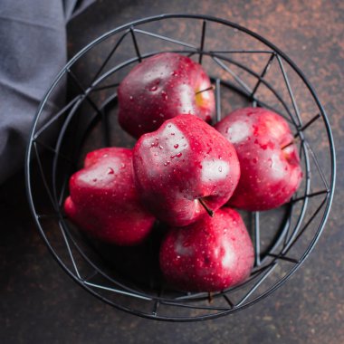 Koyu arka plan üzerinde metal sepet taze olgun Kırmızı elma