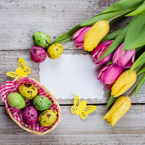 Желтые Розовые Тюльпаны Разноцветными Перепелиными Яйцами Белой Карточкой Деревянном Столе — стоковое фото