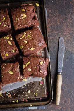 Koyu arka plan üzerine Antep fıstığı ile ev yapımı çikolatalı kek