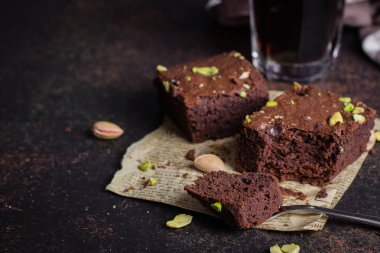 Koyu arka plan üzerine Antep fıstığı ile ev yapımı çikolatalı kek