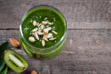 Kivi ve badem ahşap masa üzerinde taze yeşil smoothies 