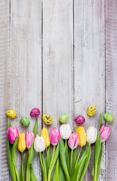 Пасхальная Композиция Тюльпанами Разноцветными Перепелиными Яйцами Потрепанном Деревянном Фоне — стоковое фото