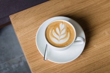 Masanın üzerinde fincanda kahve, sıcak bir ton.