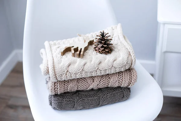 Une pile de pulls tricotés sur chaise à l'intérieur du salon — Photo