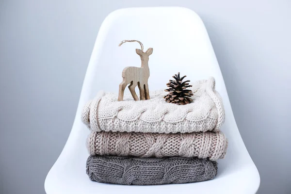 A stack of knitted sweaters on chair in Interior of the living room — Stock Photo, Image