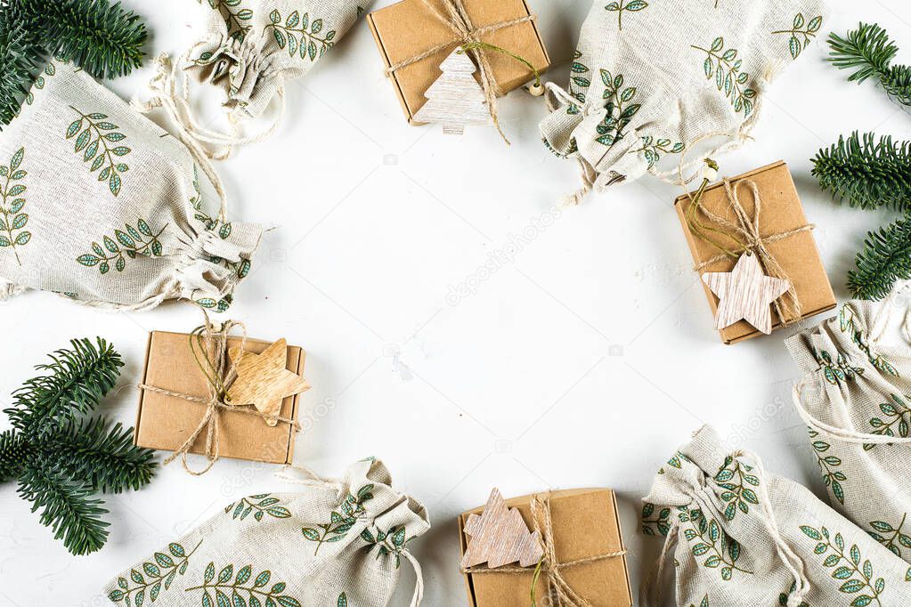 Christmas Gift Flat lay. Zero Waste Gift Wrapping Holiday Season Eco-friendly Lifestyle. Craft Boxes and Pouches with fir branch on white background. Top view, flat lay, copy space