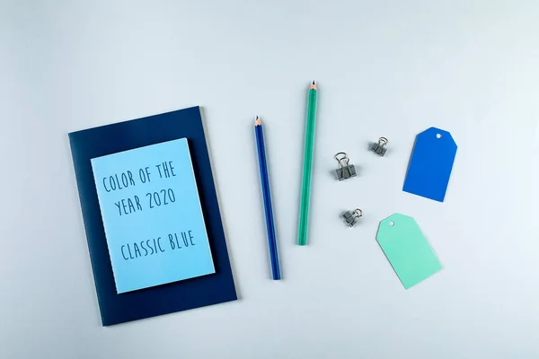 Blauwe en groene notitieboekjes met stationaire objecten op de grijze achtergrond — Stockfoto