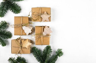Noel arkaplanı. Sıfır Atık Hediye Paketleme Tatil Sezonu Çevre dostu. Beyaz arka planda köknar dalı olan el işi kutuları. Üst görünüm, düz görünüm, kopyalama alanı