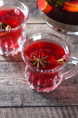 Ahşap masa zemininde baharatlar olan oryantal çilek kırmızısı çay