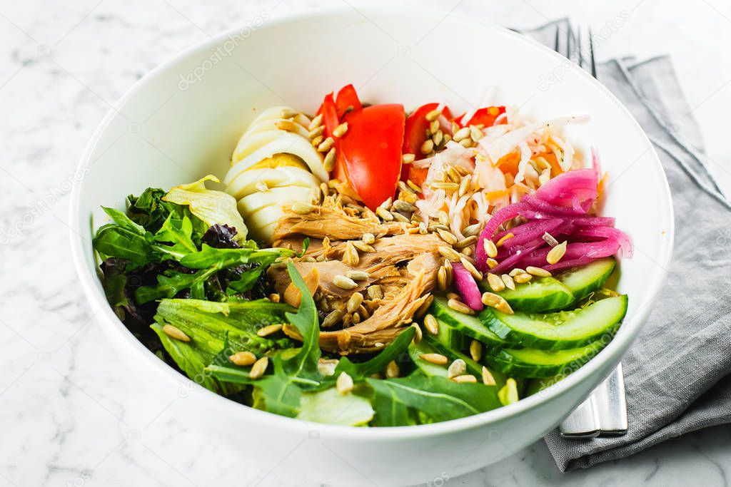 Tuna lunch bowl. Salad with green mix, vegetables, tuna and seeds. Healthy food concept, close-up