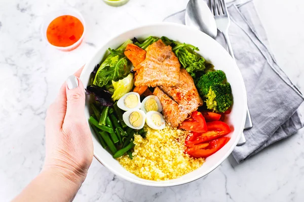 Comida saludable, concepto de comida keto. Ensaladera de pescado sobre fondo de mesa de mármol. Ensalada con salmón, cuscús, verduras, huevos de codorniz. Vista superior, espacio de copia — Foto de Stock