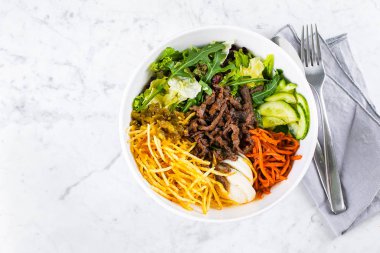 Mermer masa arka planında sağlıklı bir yemek kasesi. Lezzetli dengeli gıda konsepti. Üst görünüm, düz görünüm, kopyalama alanı