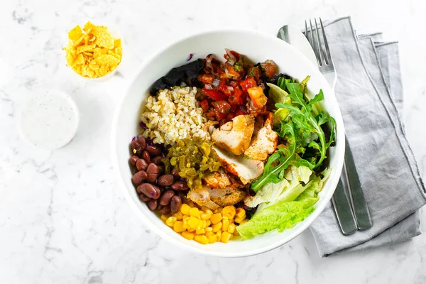 Comedor mexicano sobre fondo de mármol. Ensaladera con maíz, frijoles rojos, tomate con cebolla roja, jalapenios, pechuga de pollo, papas fritas de taco y salsa de ajo yougurt. Vista superior — Foto de Stock