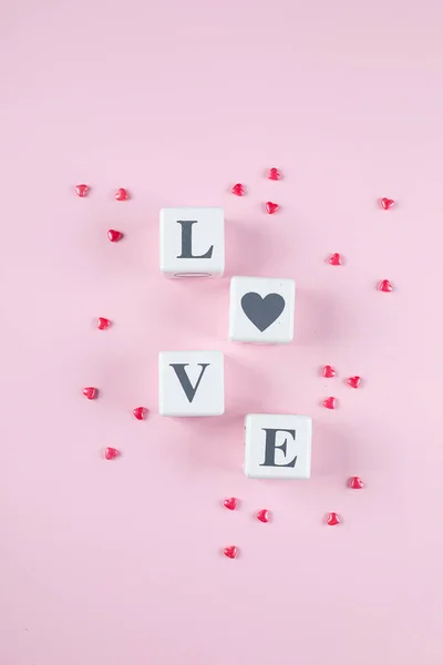 Love message written in white wooden blocks on pink background. Pink candy hearts. Flat lay, top view — 스톡 사진