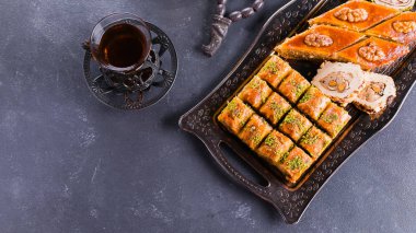 Doğulu tatlı çeşitleri. Baklava ve mavi beton bir masada iki fincan çay. Üst görünüm, kopyalama alanı, pankart resmi