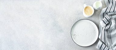 Boş seramik tabak, bir fincan kahve ve arka planda hafif taş beton masa üzerine çizgili havlu. Uzayı kopyala Menü Tarifi Konsepti. Üst Manzara. Düz yatıyordu. Tasarım için pankart, web sitesi