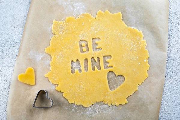 Bakery Valentine's Day Concept. Be mine text. Making homemade heart shaped cookies from shortbread raw dough. Top view — 스톡 사진