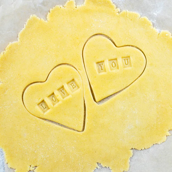 Bakery Valentine's Day Concept. Love You Card. Making homemade heart shaped cookies from shortbread raw dough. Top view. Square — 스톡 사진